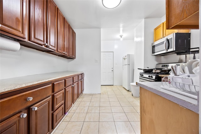 kitchen featuring light tile patterned flooring, appliances with stainless steel finishes, and light countertops