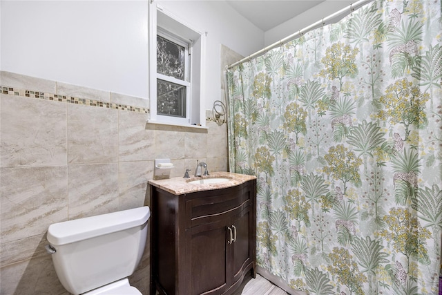 full bathroom with toilet, tile walls, and vanity