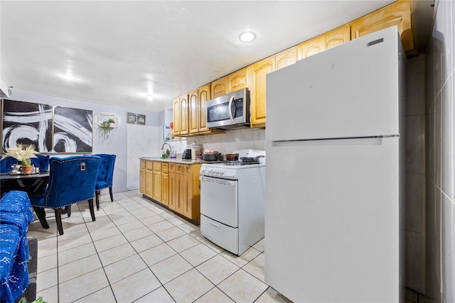kitchen with light tile patterned floors, tasteful backsplash, a sink, light countertops, and white appliances
