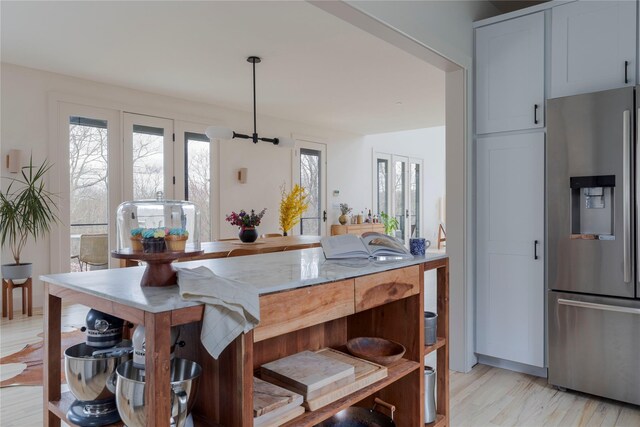 21 Private Way, Garrison, NY 10524 - kitchen with light wood-type flooring, a healthy amount of sunlight, decorative light fixtures, and stainless steel fridge with ice dispenser