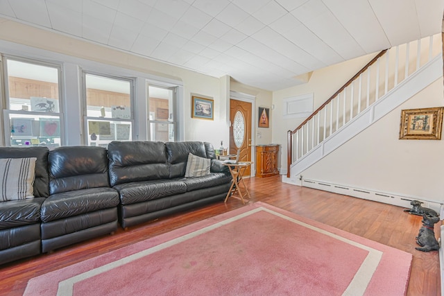 living room featuring stairs, wood finished floors, and a baseboard radiator