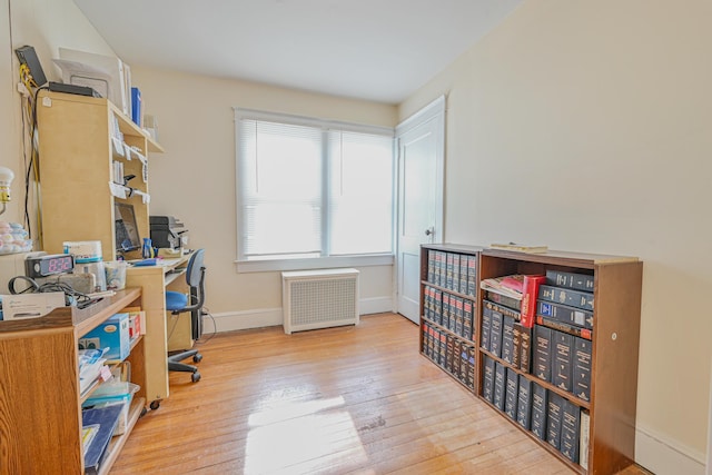 office featuring baseboards, wood-type flooring, and radiator