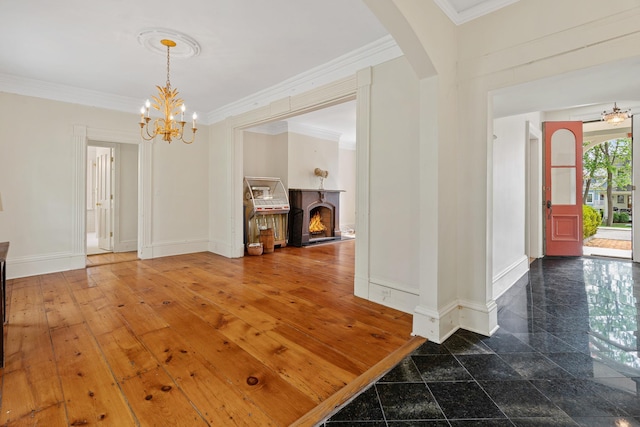 64 Paulding Ave, Cold Spring, NY 10516 - interior space with crown molding, baseboards, a warm lit fireplace, arched walkways, and a notable chandelier