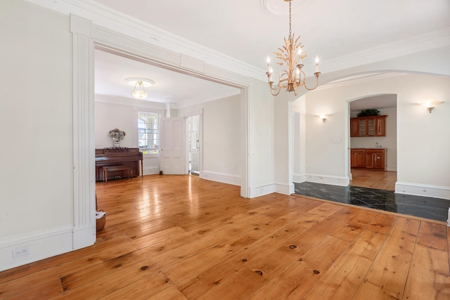 64 Paulding Ave, Cold Spring, NY 10516 - unfurnished dining area with crown molding, an inviting chandelier, hardwood / wood-style floors, baseboards, and arched walkways