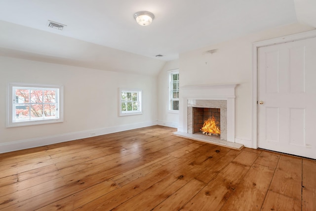 64 Paulding Ave, Cold Spring, NY 10516 - unfurnished living room featuring visible vents, a premium fireplace, baseboards, vaulted ceiling, and hardwood / wood-style flooring