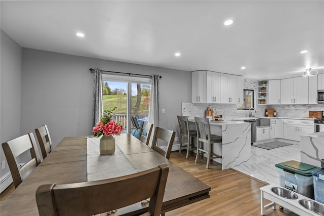 dining room with recessed lighting and light wood finished floors