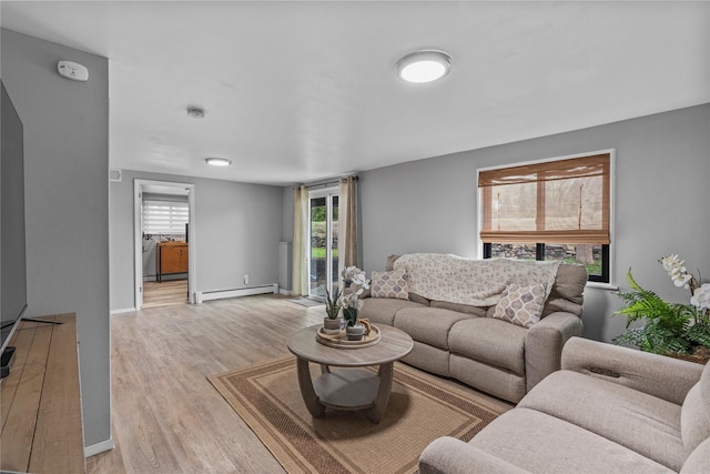 living room with baseboards, light wood-type flooring, and a baseboard radiator