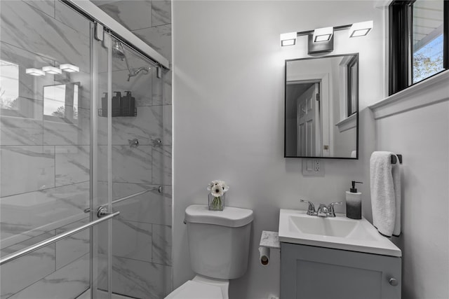 bathroom with toilet, a stall shower, and vanity