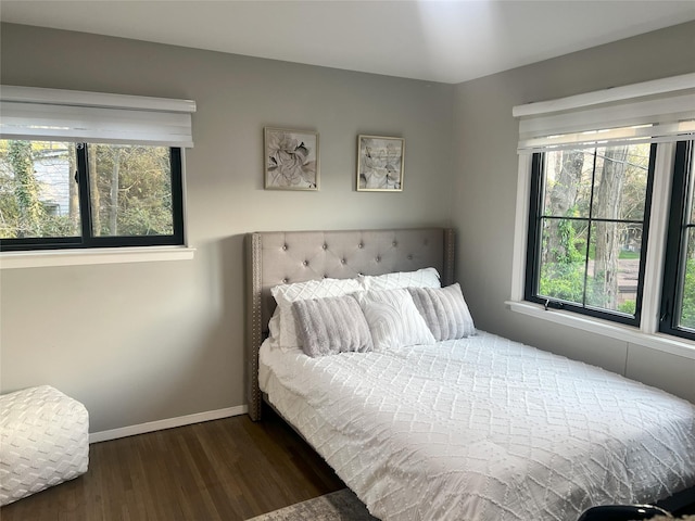 bedroom featuring dark wood-style floors and baseboards
