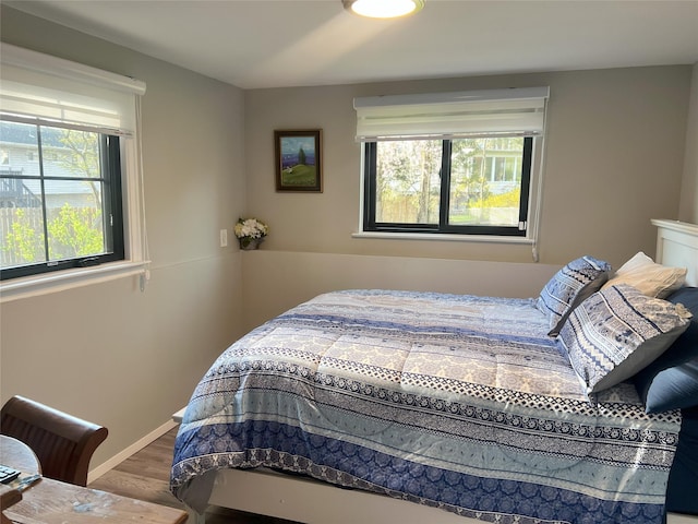 bedroom with baseboards and wood finished floors