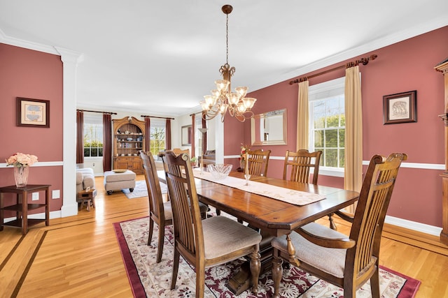 dining area featuring light wood-type flooring, an inviting chandelier, and a healthy amount of sunlight