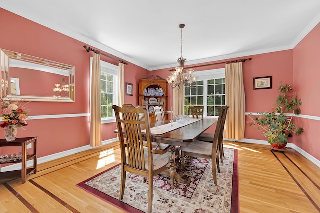 dining space featuring ornamental molding, a notable chandelier, light wood-style flooring, and baseboards