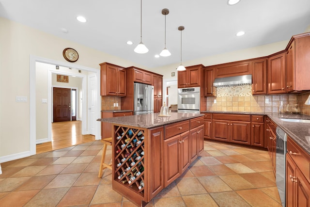 kitchen with dark stone countertops, tasteful backsplash, appliances with stainless steel finishes, ventilation hood, and a center island