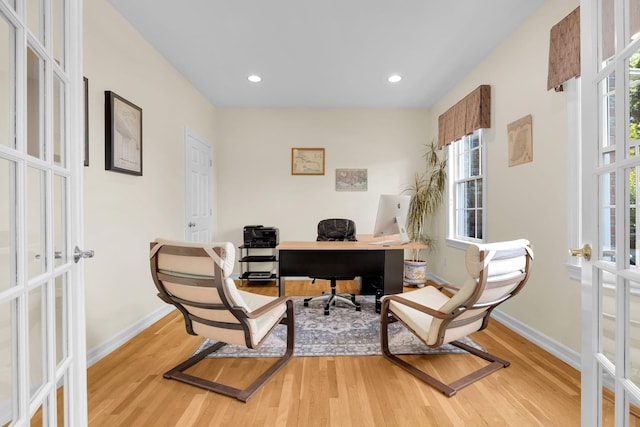office space with baseboards, light wood-type flooring, and french doors