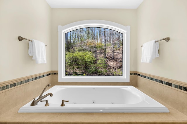 bathroom with a tub with jets and plenty of natural light