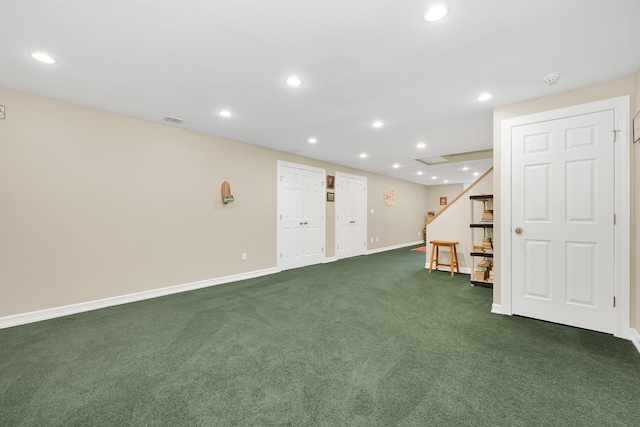 basement with baseboards, visible vents, dark carpet, and recessed lighting