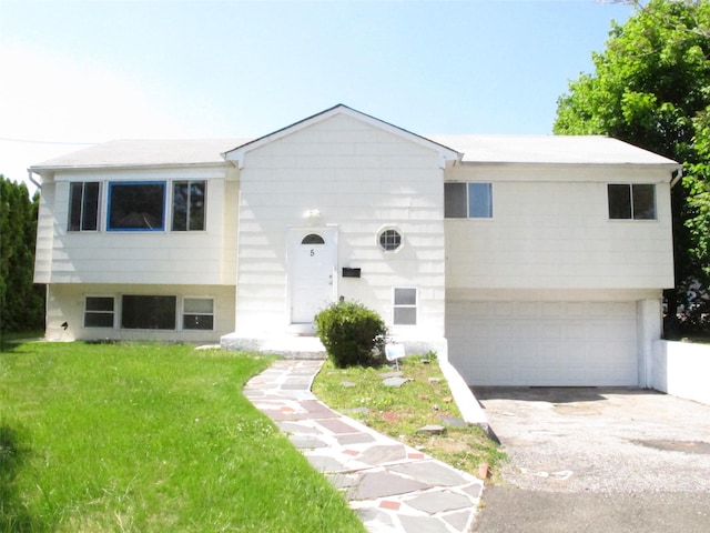 5 Elm St, Great Neck, NY 11021 - view of front of home with concrete driveway, a front yard, and a garage