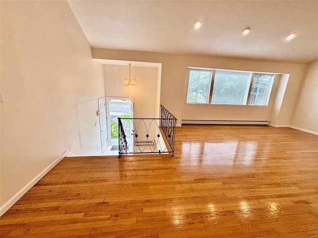 5 Elm St, Great Neck, NY 11021 - unfurnished room featuring a notable chandelier, plenty of natural light, hardwood / wood-style flooring, and a baseboard radiator