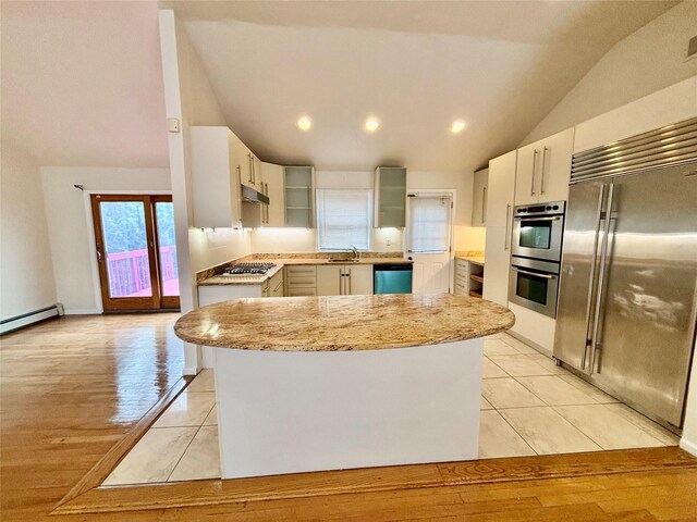 5 Elm St, Great Neck, NY 11021 - kitchen with stainless steel appliances, light tile patterned flooring, vaulted ceiling, and a sink