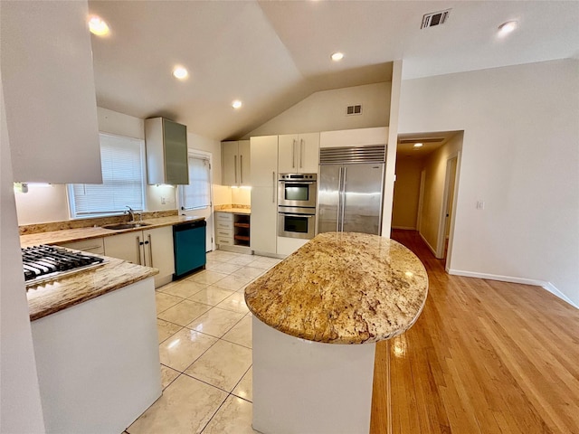 5 Elm St, Great Neck, NY 11021 - kitchen featuring appliances with stainless steel finishes, a sink, a center island, lofted ceiling, and visible vents