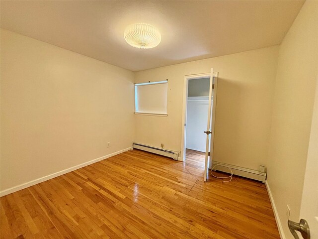 5 Elm St, Great Neck, NY 11021 - unfurnished room featuring baseboards, baseboard heating, light wood-style flooring, and a baseboard radiator
