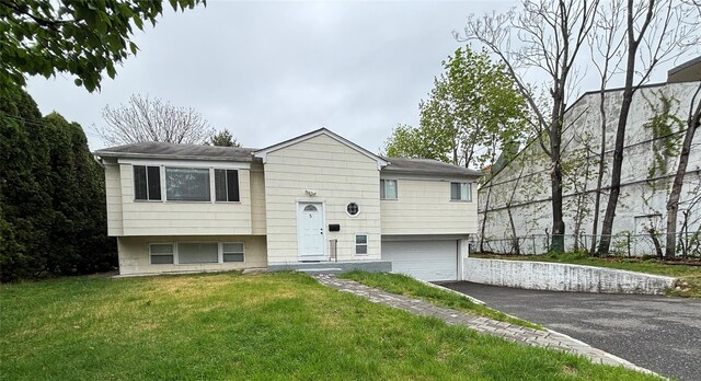 5 Elm St, Great Neck, NY 11021 - raised ranch featuring fence, an attached garage, driveway, and a front lawn