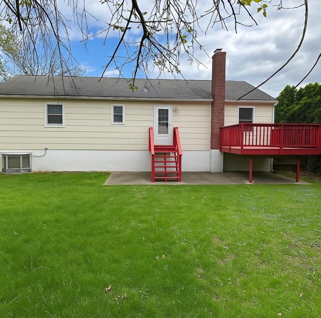 5 Elm St, Great Neck, NY 11021 - back of house featuring a wooden deck, a chimney, cooling unit, a patio area, and a lawn