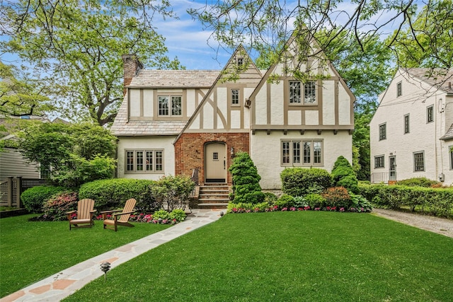 10 Maple Hill Dr, Larchmont, NY 10538 - tudor-style house with stucco siding, a high end roof, a chimney, and a front yard
