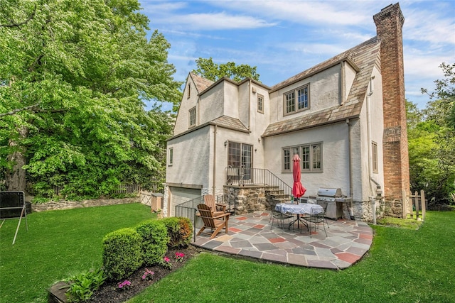 10 Maple Hill Dr, Larchmont, NY 10538 - rear view of house featuring stucco siding, a chimney, a patio, and an attached garage