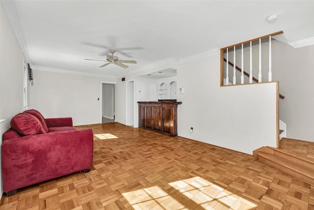 living room with stairway, ornamental molding, and a ceiling fan