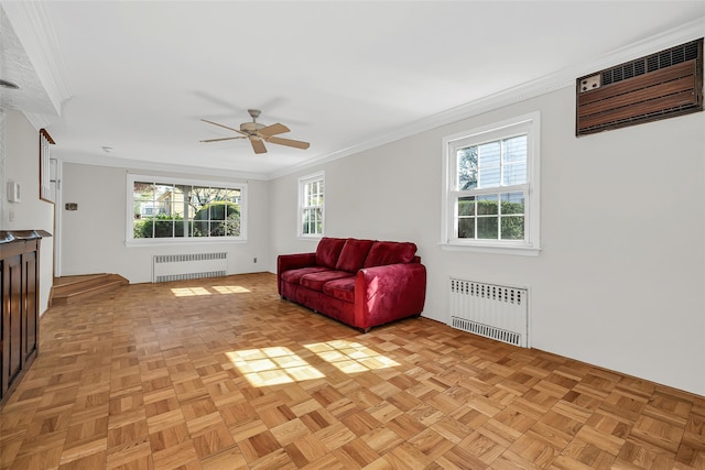 sitting room with radiator, ceiling fan, and crown molding