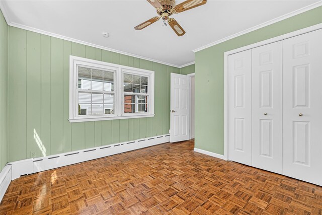 unfurnished bedroom with a closet, a ceiling fan, baseboards, ornamental molding, and baseboard heating