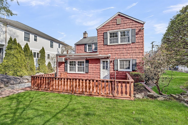 view of front of property featuring a chimney, a wooden deck, and a front yard