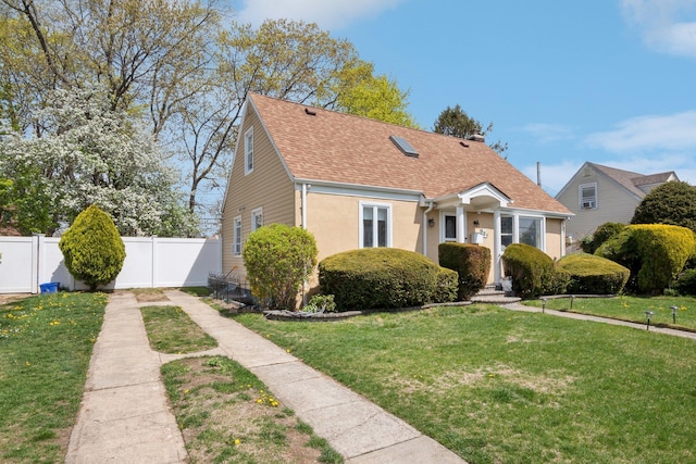 bungalow-style home featuring fence, a chimney, a shingled roof, and a front lawn