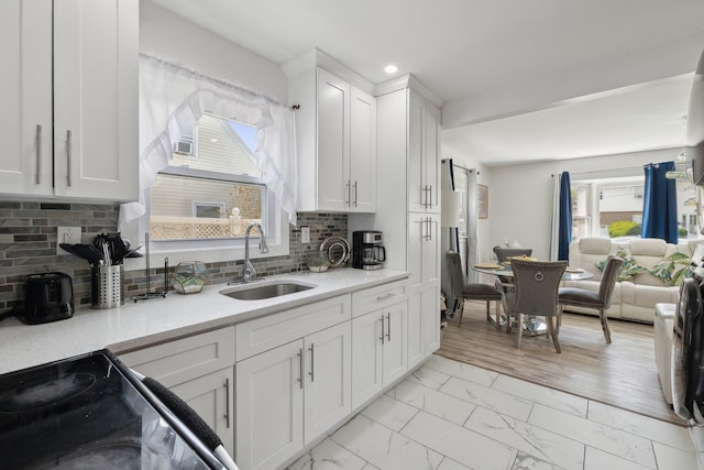 kitchen with white cabinets, a sink, electric range, recessed lighting, and marble finish floor