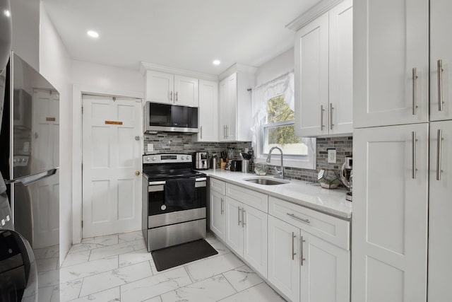 kitchen with marble finish floor, a sink, stainless steel appliances, and tasteful backsplash