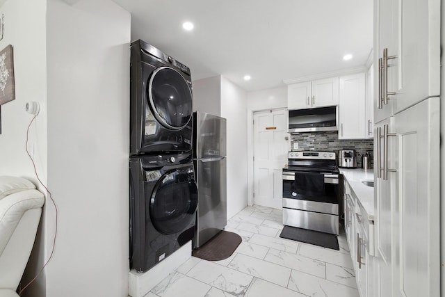 kitchen with stacked washer and dryer, white cabinetry, decorative backsplash, stainless steel appliances, and marble finish floor