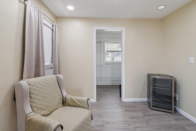 living area featuring recessed lighting, wine cooler, heating unit, light wood-type flooring, and baseboards