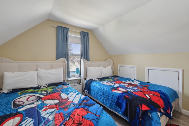bedroom with wood finished floors and vaulted ceiling