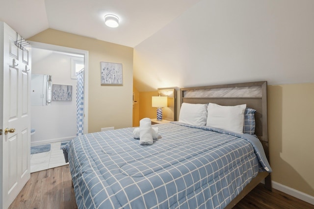 bedroom with lofted ceiling, wood finished floors, and baseboards