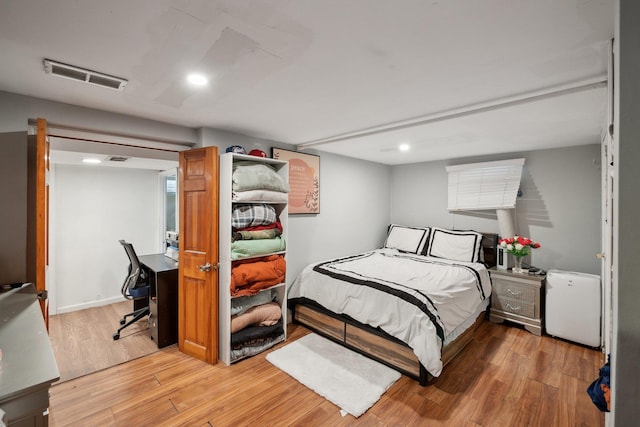 bedroom with recessed lighting, visible vents, and wood finished floors