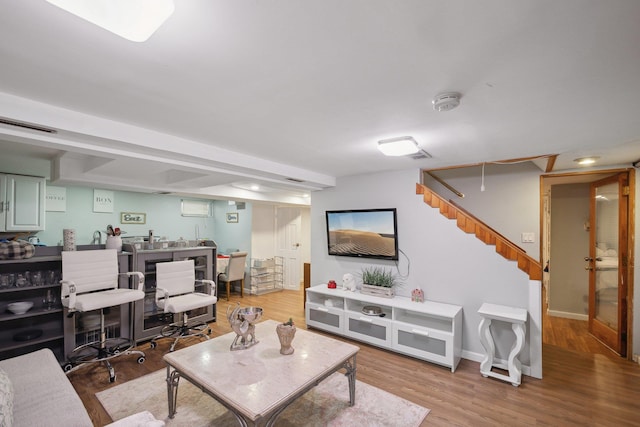 living room with baseboards, wood finished floors, and stairs