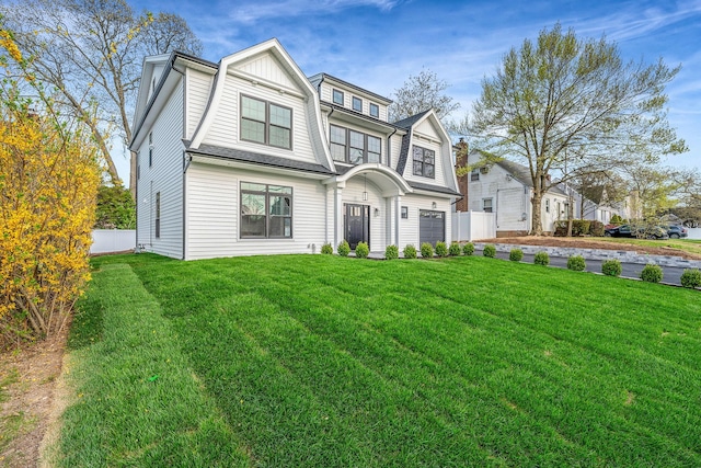 shingle-style home featuring fence, driveway, a front yard, and a garage