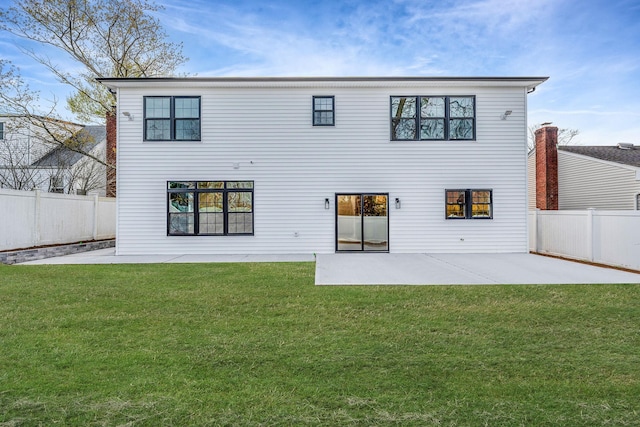 rear view of property featuring a lawn, a fenced backyard, and a patio area