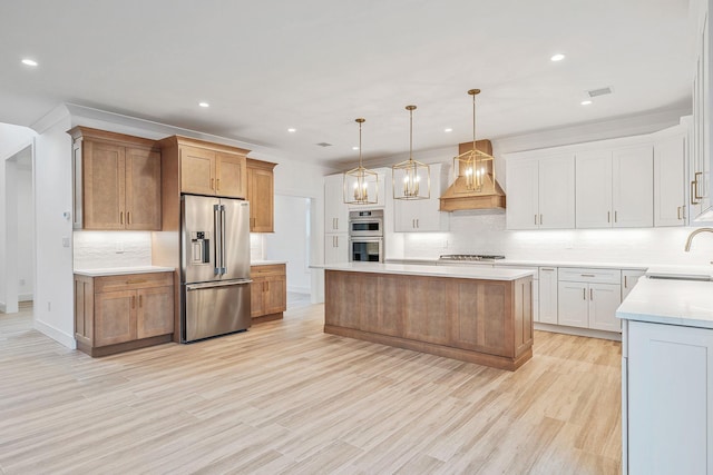 kitchen featuring decorative backsplash, a sink, light countertops, custom exhaust hood, and stainless steel appliances