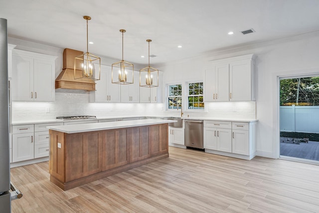 kitchen featuring visible vents, light countertops, custom range hood, backsplash, and stainless steel appliances