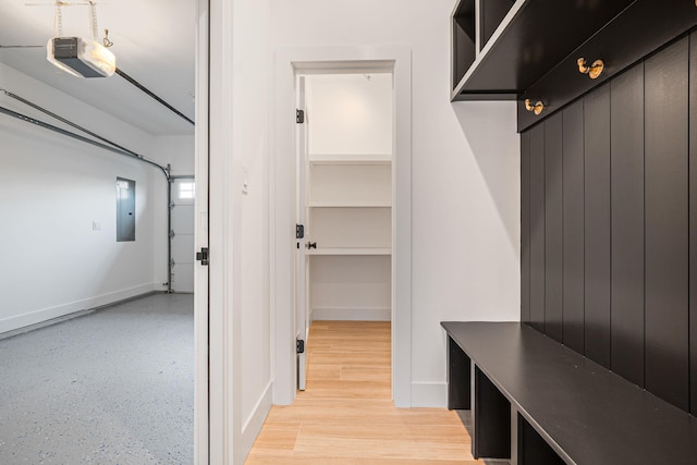 mudroom with baseboards and electric panel