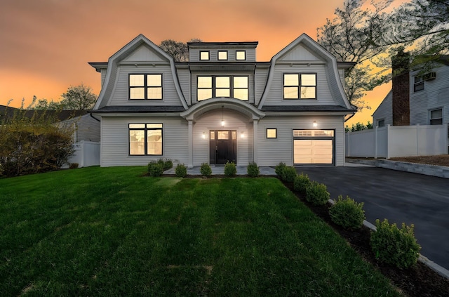 shingle-style home featuring fence, a yard, driveway, and a gambrel roof