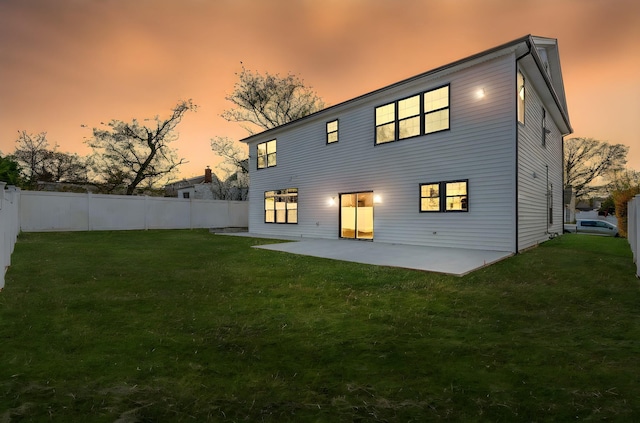 rear view of house with a lawn, a patio area, and fence