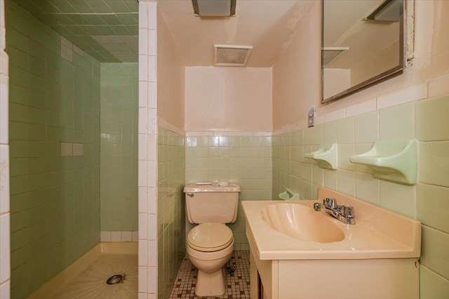 full bathroom featuring visible vents, tile walls, toilet, and tiled shower